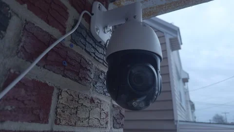 PTZ Security Camera on Weathered Brick Wall of Suburban Home Vidéo 330671674