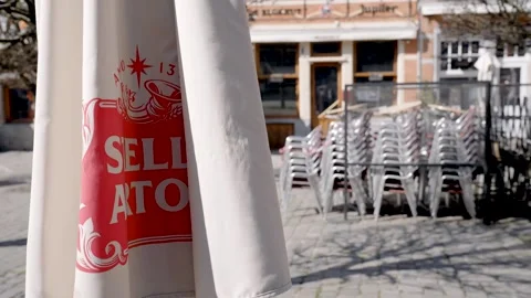 Pub umbrella waving lonely in the wind at Oude Markt, Leuven. Cafes and Stock Footage 151008174