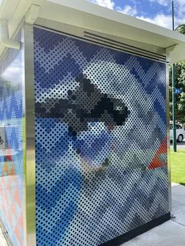 Public art mural featuring pixelated cross-stitch design on a modern utilit.. Stock Photos