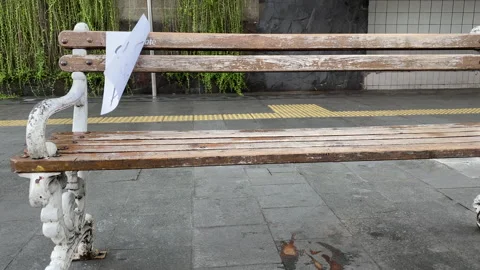 A Public Bench on a Sidewalk with a Reminder During Covid-19 Pandemic Stock Footage 156438816
