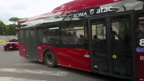 Public bus driving through a Roman intersection with zebra crossing and bell Stock Footage 312600232