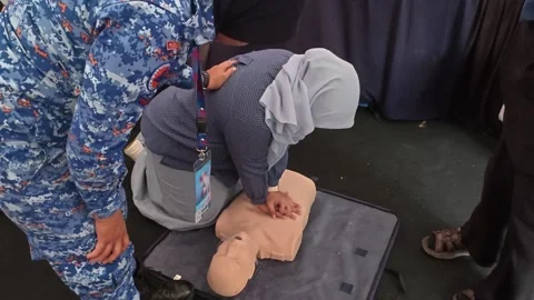 Public CPR and First Aid Demonstration by Rescuers at Community Carnival Stock Footage 340986640