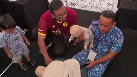 Public CPR and First Aid Demonstration by Rescuers at Community Carnival Stock Footage 340986670
