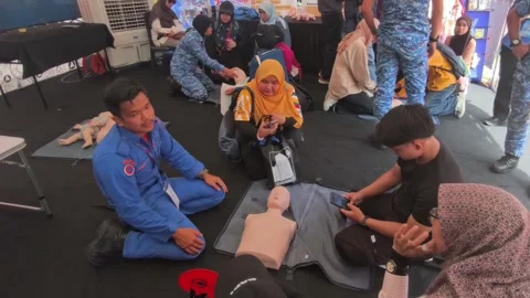 Public CPR and First Aid Demonstration by Rescuers at Community Carnival Stock Footage 340986723