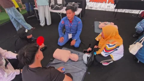 Public CPR and First Aid Demonstration by Rescuers at Community Carnival Stock Footage 340986760