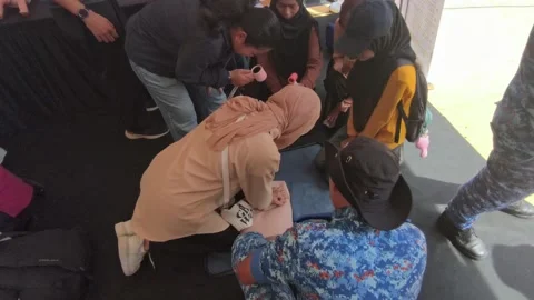 Public CPR and First Aid Demonstration by Rescuers at Community Carnival Stock Footage 340986793