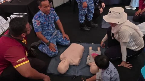 Public CPR and First Aid Demonstration by Rescuers at Community Carnival Stock Footage 340986827