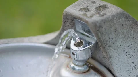 A public drinking fountain flows in a park setting in 4k slow motion 120fps Stock Footage 284524912