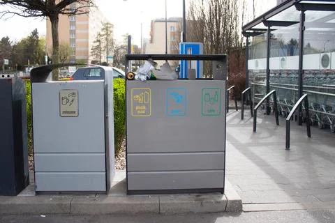 Public garbage bin with waste separation on a city street filled with garbage Stock Photos