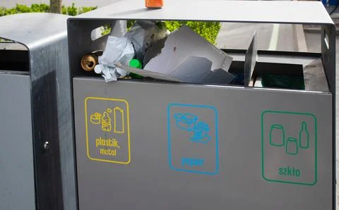 Public garbage bin with waste separation on a city street filled with garbage Stock Photos
