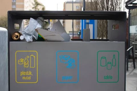 Public garbage bin with waste separation on a city street filled with garbage Stock Photos