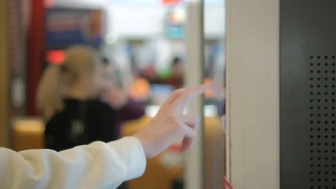 At a public place, a person is interacting with a screen against a blurry Stock Footage 276491142