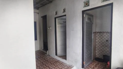 Public restroom facility corridor with multiple shared toilet stalls in a c.. Stock Photos
