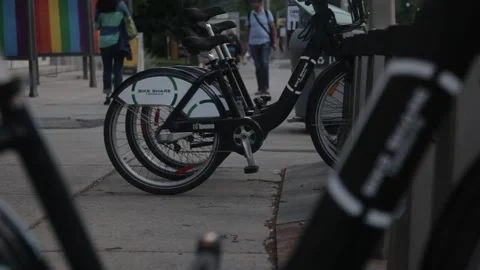 Public shared bicycles parked at a city bike share station Stock Footage 341032763
