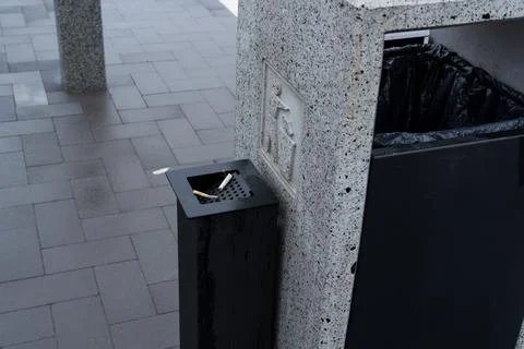 A public space features a solid waste container with a designated area for .. Stock-Fotos