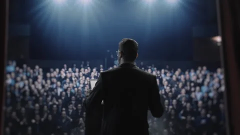 Public Speaker Addressing Large Audience In Dark Theater Conference Leadership Stock Footage 291887481