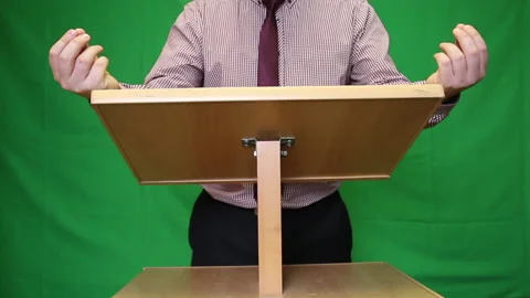 Public speaker behind the podium. A man in a shirt and tie says something and Stock Footage 221311650
