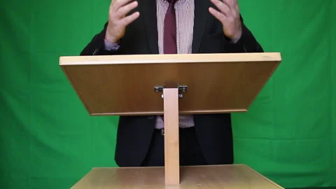Public speaker behind the podium. A man in a suit and tie says something and  Stock Footage 221311688