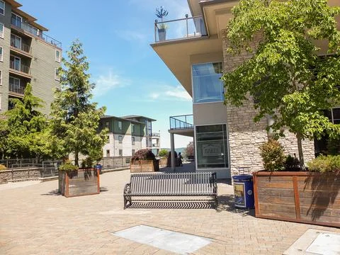 Public square at Baker Condominiums featuring metal benches, wooden planter.. Stock Photos