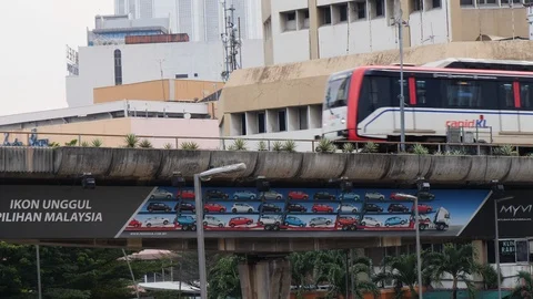Public train riding on bridge above city shops, Kuala Lumpur, Malaysia Stock Footage 146558256