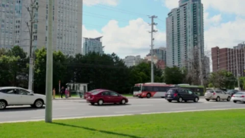 Public transit bus approaching bus stop amidst traffic. Stock Footage 76200956