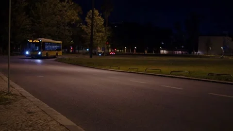 Public transit bus driving on an empty urban road at night with headlights .. Stock Footage 335858989