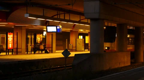 Public transport train is leaving while people sitting at the station. Stock Footage 66948399