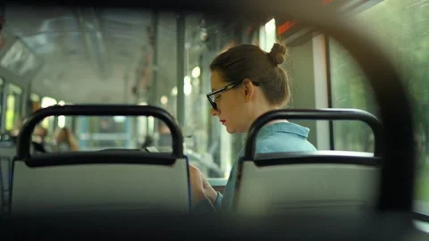 Public transport. Woman in tram using smartphone, back view, slow motion. Video stock 252242527
