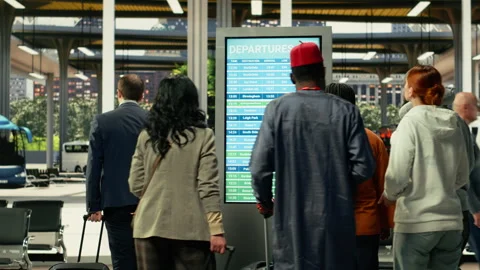 Public transportation scene showing commuters checking timetable screen Stock Footage 334728542