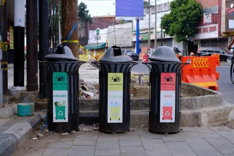 Public trash cans categorized by type of organic, plastic and glass waste Stock Photos