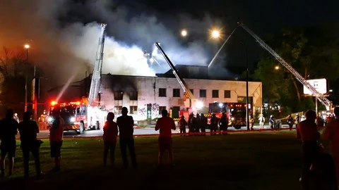 Public watching vacant building burning Stock Footage 116013216
