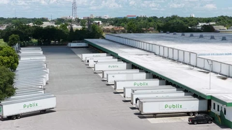 Publix delivery trucks line loading docks at massive distribution warehouse in Stock Footage 339413536