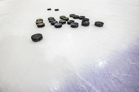 Pucks on empty ice rink Stock Photos