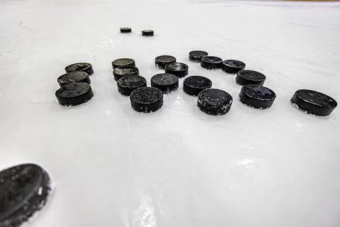 Pucks on empty ice rink Stock Photos