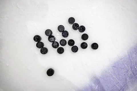 Pucks on empty ice rink Stock Photos