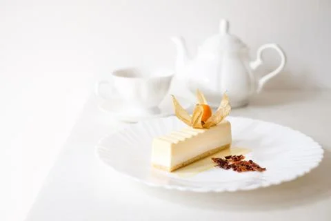 Pudding cake on white plate with tea cups Stock Photos