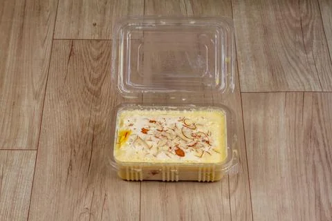 Pudding in plastic container on wooden background. Stock Photos