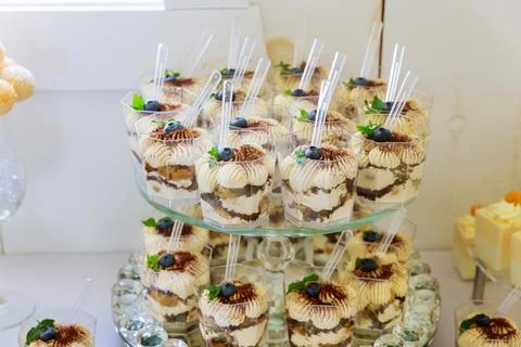 Pudding, pound cake and berries in cups on cake stand. Stock Photos