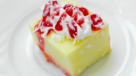 Pudding with strawberry jam and cream, rotates on white plate, top view Stock Footage 54230007