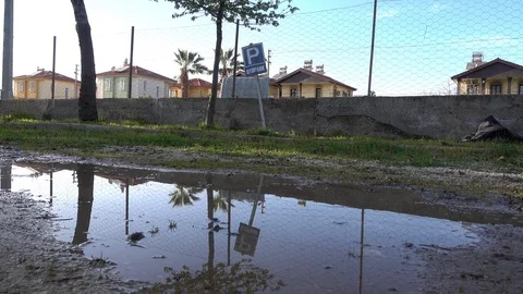 Puddle and paking sign reflected in it Stock Footage 88167571