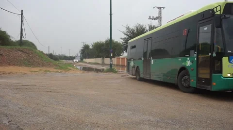 Puddle in the background, green bus in front, Israel Stock Footage 56707144