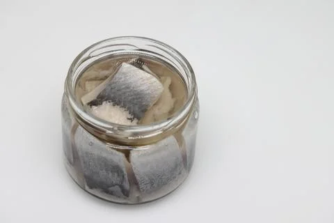 Puddle of condensed milk flows from levitating jar, can opener, black bread Foto stock