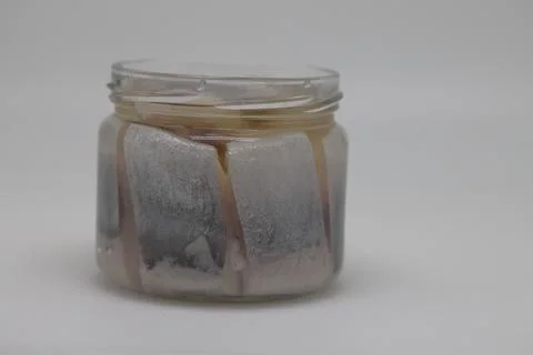 Puddle of condensed milk flows from levitating jar, can opener, black bread Foto stock