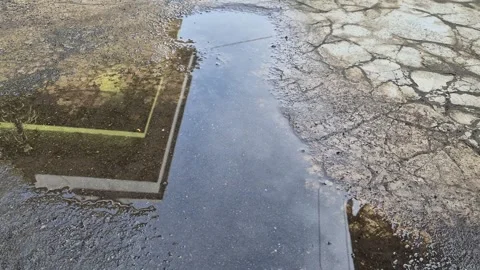 A puddle on cracked asphalt reflects a house. Stock Footage 340847384