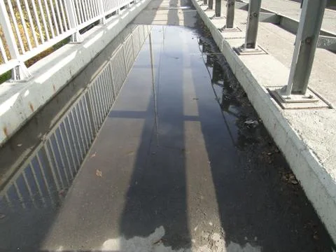 Puddle with lantern reflection on the footbridge Stock Photos