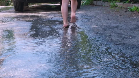 Puddle on the pavement. Drops of rain fall into Stock Footage 247996675