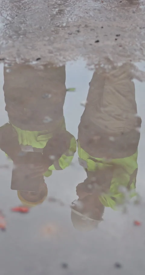Puddle, reflection and engineer at construction site with team, check foundation Stock Footage 340960349