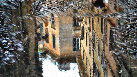 Puddle Reflection in the Rain Yellow Buildings 4K Loop Stock Footage 99754569