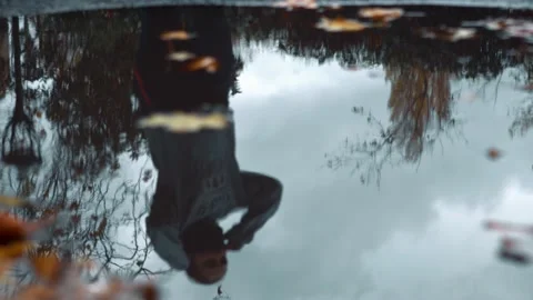 Puddle Reflection shot of Woman Running on Autumn/Fall day Video stock 142947351