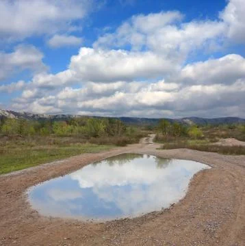 Puddle on road after rain Stock Photos